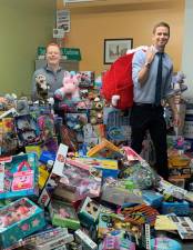 Councilmember Eric Bottcher (right) standing amidst a pyramid of toys that were collected last year. (Photo: Supplied by Eric Botcher’s office)