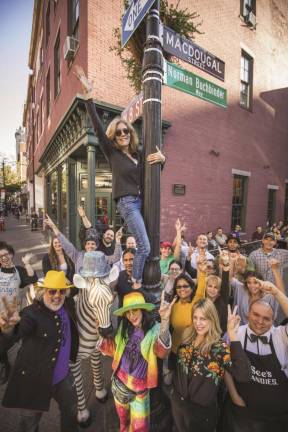 Betsy Bober Polivy on the 8th Street and MacDougal sign pole surrounded by business owners. The photo was taken when the Manhattan Sideways website won the 2017 “Best of Manhattan.” Photo: Manhattan Sideways (sideways.nyc)