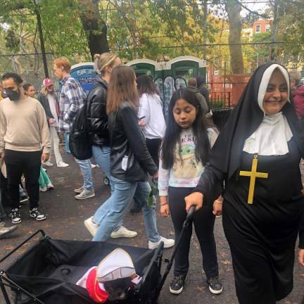 A Mother Superior pulling the “Pope” in his own Popemobile wagon was a crowd pleaser. Photo: Keith J. Kelly