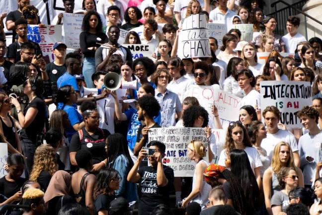 Teens Take Charge, a coalition led by NYC students advocating for more equitable high school admissions, held a protest at the Tweed Courthouse in Manhattan. Students of color wearing black sat on the left side of the steps, while white students wearing white sat on the right, visually representing school segregation.
