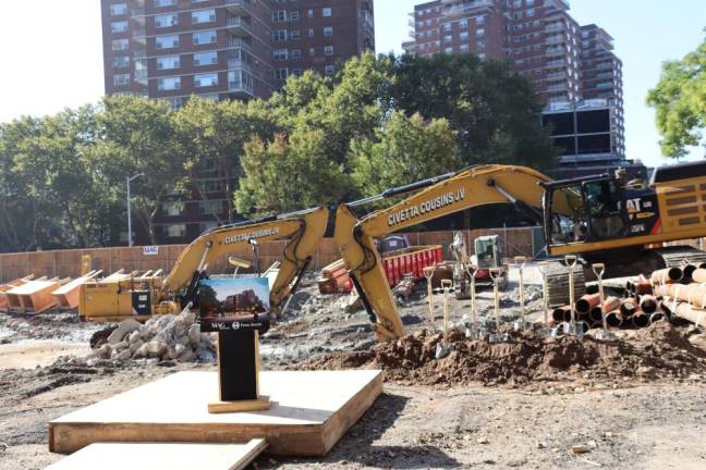 An excavator breaks ground at the site of the 335 Eighth Ave. development on Oct. 3.