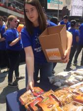 Hundreds of volunteers converged on Times Square recently to package 36,000 meals for needy NYC children. In a “Day of Global Giving,” volunteers from Morgan Stanley distributed 2.1 million meals to hungry children around the world, in events that took place across the globe. Photo: Mike London of Michael J. London &amp; Associates