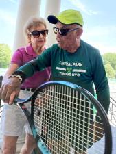 Langley Danowitz gets a hands-on grip lesson from Yale Lang, a 91 1/2 year old tennis player who was once a tennis coach. He can be found on the Central Park tennis courts almost every weekday.