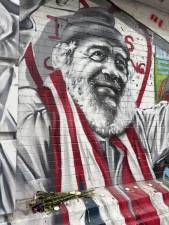 Carlos “Chino” Garcia draped in Puerto Rican flag on a mural at P.S. 64 / Charas on East 10th Street.