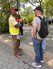 A ticket vendor approaches visitors outside the Bowling Green subway station near Battery Park.