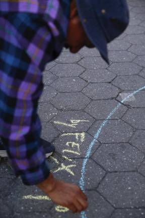 For artist Felix Morelo, his work is about breaking social barriers. Drawing on the ground in chalk, he creates Good Luck Spots to persuade people who are walking by to interact with each other. At Union Square Park, May 2022. Photo: Gabo Rodriguez-Tossas