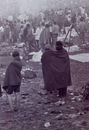 Young people banded together to try to keep one another dry when the rains came on the second day of the music festival. Photo: Mark Goff, Wikimedia Commons