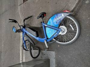 A Citi Bike with a broken tire laying on the side of the street in Hell’s Kitchen.