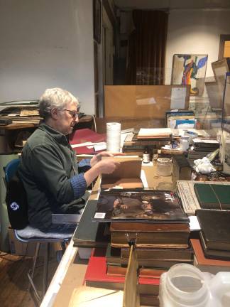 Richard Rosenblatt, at his computer-free desk, examines his latest book-restoration project. “I’ll open the book, explore what needs to be done, and where I think I could help the book along.”