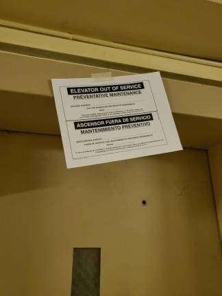 Sign showing that one of the building’s two elevators is out of order.