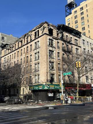A view of 201 W. 107th St. at around 11:30 a.m., roughly one hour after a blaze that engulfed its top floor had been extinguished.