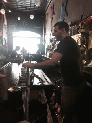 Amonte Demarko, who's worked at Candle Bar for about 12 years, the last 10 as its manager, at the bar on its last night of business. Photo: Logan Hendrix