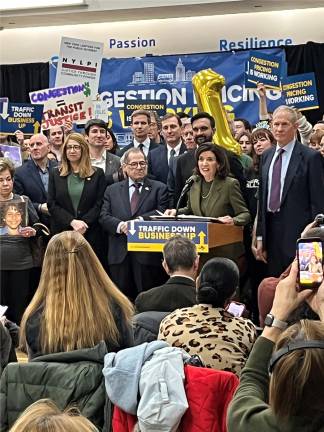 As Governor Kathy Hochul speaks. congestion pricing supporters including Congressmen Jerry Nader and Dan Goldman, Mayor Zohran Mamdani and MTA Chair and CEO Janno Lieber listen attentively.