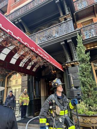 <b>Firemen exit the Chelsea Hotel after extinguishing blaze that erupted in kitchen and spread to second floor.</b>