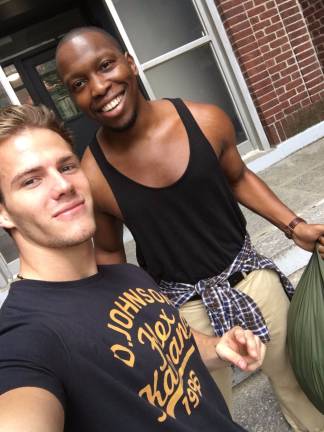 Building for Better founder and CEO Michael Dean Johnson with a Chelsea resident. Photo: Kevin Sowyrda