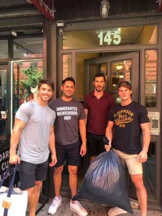 Building for Better board member Sean Alexander (far left) and Building for Better founder and CEO Michael Dean Johnson (far right) with Chelsea residents collecting clothing. Photo: Kevin Sowyrda