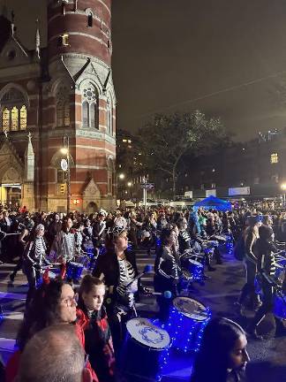 A marching band dressed as skeletons strut to the beat of their lively music.