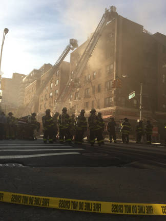 Firefighters at the scene of a five-alarm fire on East Ninth Street and Broadway Wednesday evening. Photo: Bryse Ciallella