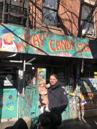 Neighborhood resident Josh Bowen stopped by Ray’s Candy Store the day after he heard of the attack on owner Ray Alvarez, whose store has been an East Village fixture for nearly 50 years. “He’s the equivalent of a saint,” says Bowen as he holds his daughter Billie after stopping by to check up on Alvarez. Photo: Keith J. Kelly