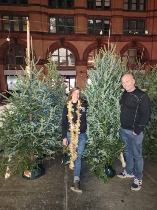 Heather Neville (with lights) says she places her Christmas tree orders in June. Her husband Dave, who is a roofer by trade, has time to assist her when bad weather slows down construction jobs in winter. Photo: Courtesy of Heather Neville