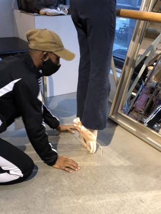 Tevin Johnson fitting pointe shoes for a dancer. Photo: Lea Efran