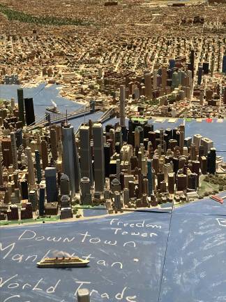 A birds-eye view of Lower Manhattan, with Macken’s handmade renderings of both the Twin Towers and One World Trade Center (Freedom Tower). Downtown Brooklyn, the Brooklyn Bridge and the Manhattan Bridge can be seen in the distance.