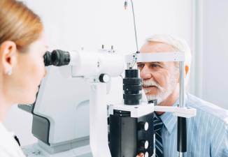 Senior man examined by an ophthalmologist, eye exam.