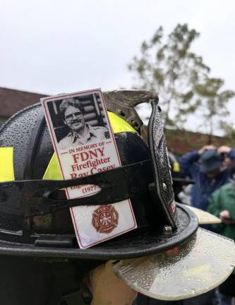 A memorial card for FDNY firefighter and 9/11 first responder Ray Casey on the helmet of Bridgehampton volunteer firefighter, Captain Kari Vecsey.