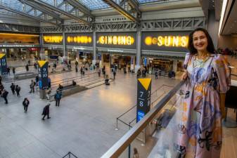Artist Shahzia-Sikander stands before her massive LED art work “The Singings Suns” at the Moynihan Train Hall. The display changes every 15 minutes. Photo: Amtrak