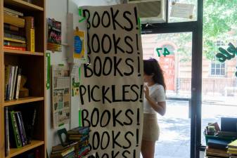 Sweet Pickle Books owner Leigh Altshuler behind sign. Photo: James Pothen
