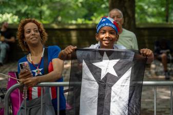 A young supporter at the Puerto Rican Day Parade flies a black and white Puerto Rican Flag; a symbol of resistance to American control.