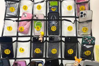 Students in a statistics class at New Heights Academy Charter School in Manhattan’s Harlem store their phones in pouches at the back of the classroom on Tuesday, May 6, 2025. A statewide cellphone ban will take effect this fall.