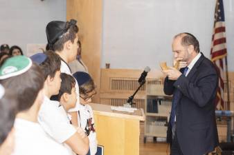 Rabbi Chaim Steinmetz sounds the shofar on loan from the Museum of Jewish Heritage's exhibition, Auschwitz. Not long ago. Not far away.