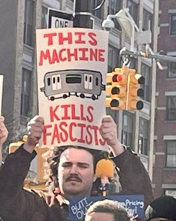 At a pro-congestion-pricing rally, Riders Alliance member Benjy Ross of Brooklyn made his thoughts known to all, borrowing a sentiment from the late singer-songwriter Woody Guthrie. The wall was headlined by Gov. Kathy Hochul on March 21.