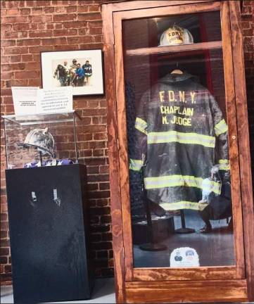 The turnout jacket and helmet worn by FDNY chaplain Fr. Mychal Judge on the day he perished while praying on the ground floor of the north tower on 9/11 are back on permanent display at the reopened Fire Museum on Spring Street.