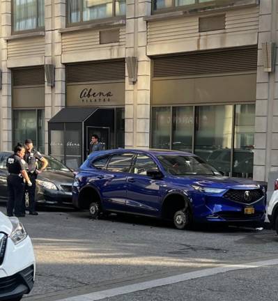 Cops ponder a wheeless blue Acura outside Abena Pilates, West 64th Street, July 2025.