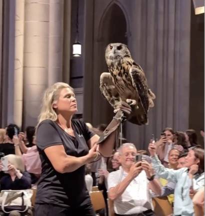 A woman and her giant owl at the Cathedral of St. John the Divine.