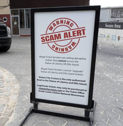 Warning: Scam Alert signs are all over Battery Park, trying to save tourists from deception.