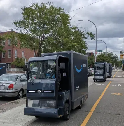 Engine powered Amazon “micromobility” trucks on a Brooklyn Greenway, note bike lane symbols.