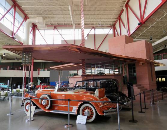 This image, inside the Buffalo Transportation Pierce-Arrow Museum has three unique items: two Pierce-Arrow automobiles from the 1930s under the Frank Lloyd Wright-designed Buffalo Filling Station, which was meant for a downtown Buffalo intersection. The 1,600-square-foot building was designed in the 1920s, and opened here in 2014. Inside, there is an observation room on the second floor with a fireplace, restrooms, and a large copper roof that acted as a gas tank; cars were to be filled from there using tubes from the roof.