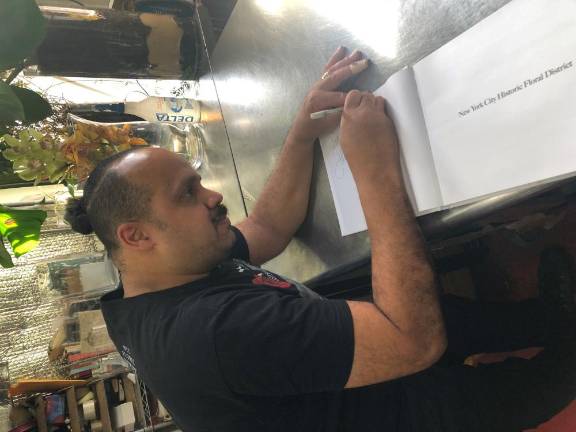 James Francois Pijuan signs a copy of his new book on the history of the Floral District in is studio on W. 28th St. Photo: Keith J. Kelly