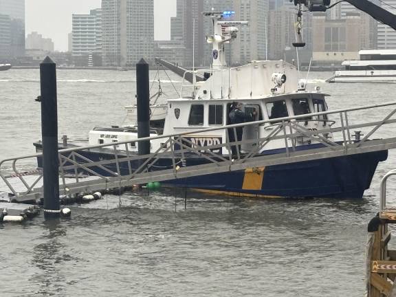 An NYPD police boat returns to Pier 40 in Greenwich Village after trying to assist in the rescue of six people who died after the helicopter they were riding in plunged into the Hudson River on April 10.