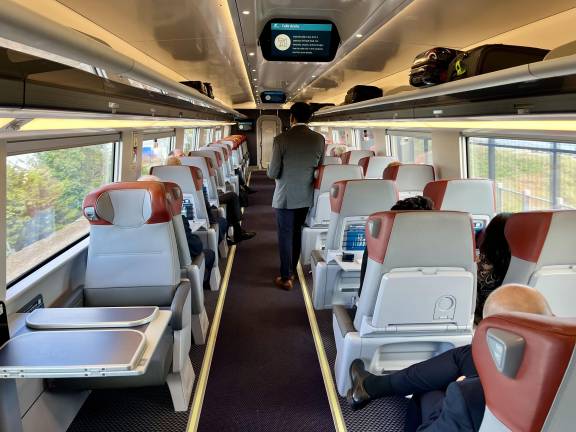 The first-class car on the NextGen Acela offers a 2-1 seating pattern, with a table for two people at the left foreground. Both hot-meal service and beverage offerings are included in the first-class fare.