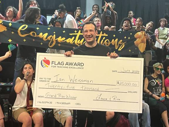 Ian Weissman, a teacher at Repertory Company High School for Theatre Arts, holds his giant $25K check in 2025.