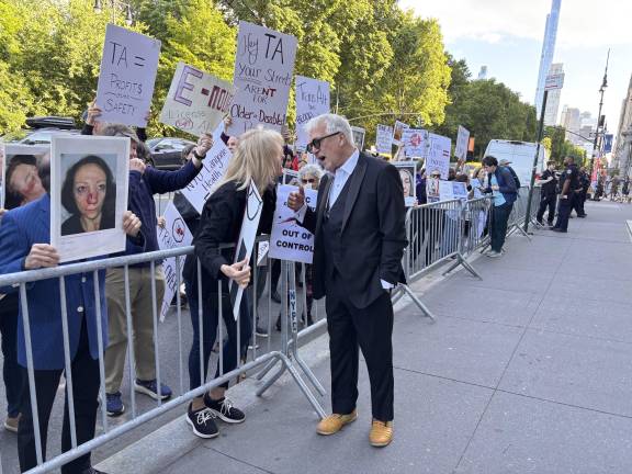 A Transportation Alternatives supporter speaks with a protester outside the organization’s annual fundraiser on Central Park West.