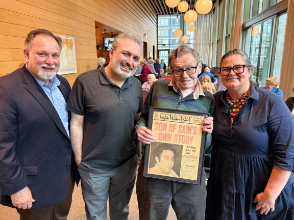 Resident and retired journalist Patrick Sullivan, holding a framed New York Post cover at Inspīr Carnegie Hill.