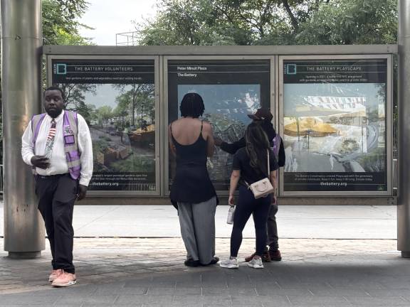 An unlicensed ticket vendor show maps and tour information to visitors near Battery Park.