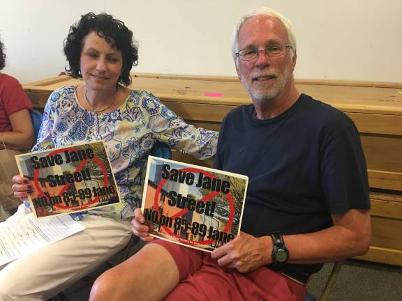 Rosemary Kristiansen and Ron Shipley holding signs in protest of the planned Jane Street development, at the LPC hearing. Photo by Madeleine Thompson