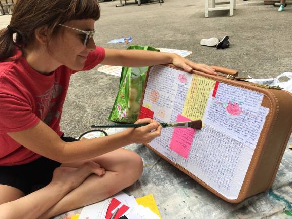 Sara Gozalo, supervising co-coordinator for the city-based New Sanctuary Coalition, decorating the suitcase that she is going to carry to a July 26 march in support of immigrants and would-be deportees. &quot;We have friends who have told us,&#xa0;'when you are in detention and you get a letter, that's like a treasure,'&quot; she said.&#xa0;Photo courtesy of Sara Gozalo