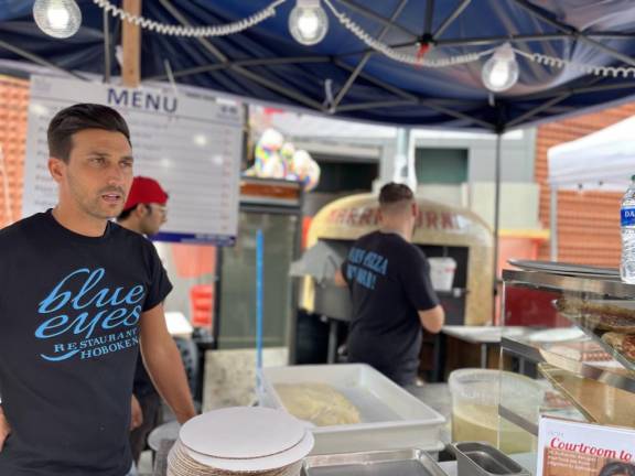 Alessandro Galeotti, a restaurateur originally from Palermo, Sicily, mans the outdoor pizza stand owned by pizzeria Blue Eyes. Photo: Kay Bontempo